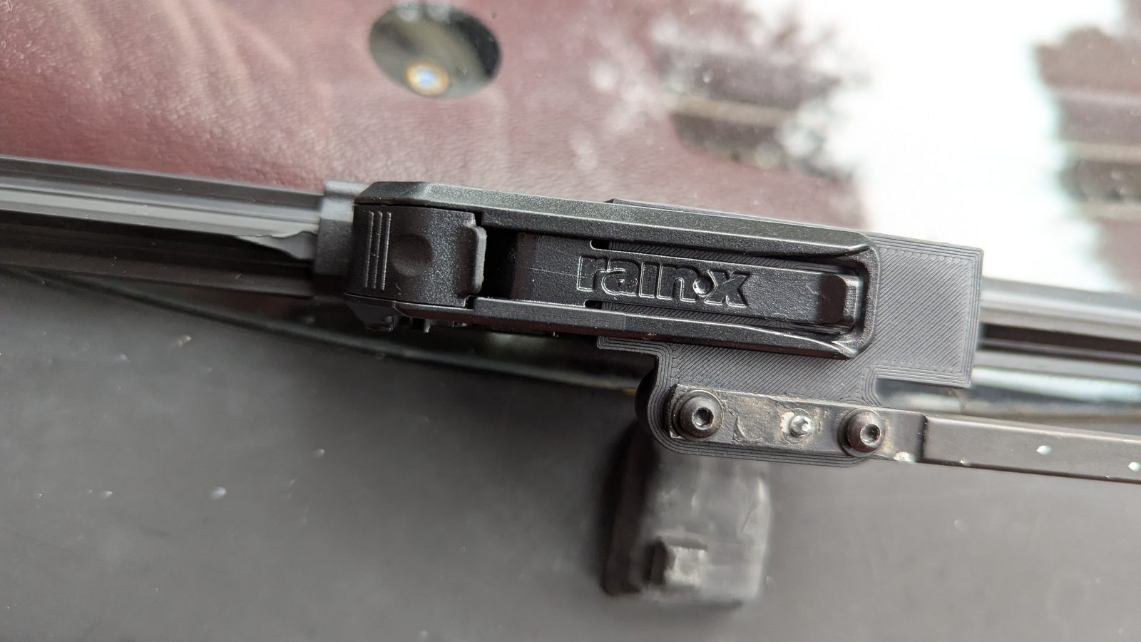 A printed adaptor on the original wiper arm, holding a Rain-X blade connector, in long-term testing.
